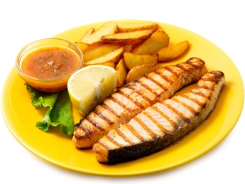 Salmon on grill with sauce and french fries